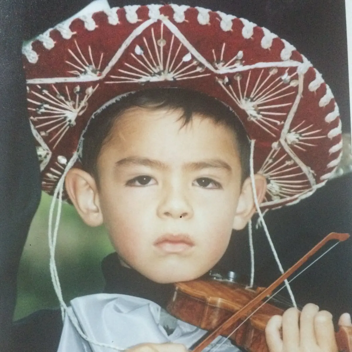 Nico González de niño vestido de mariachi con un violín